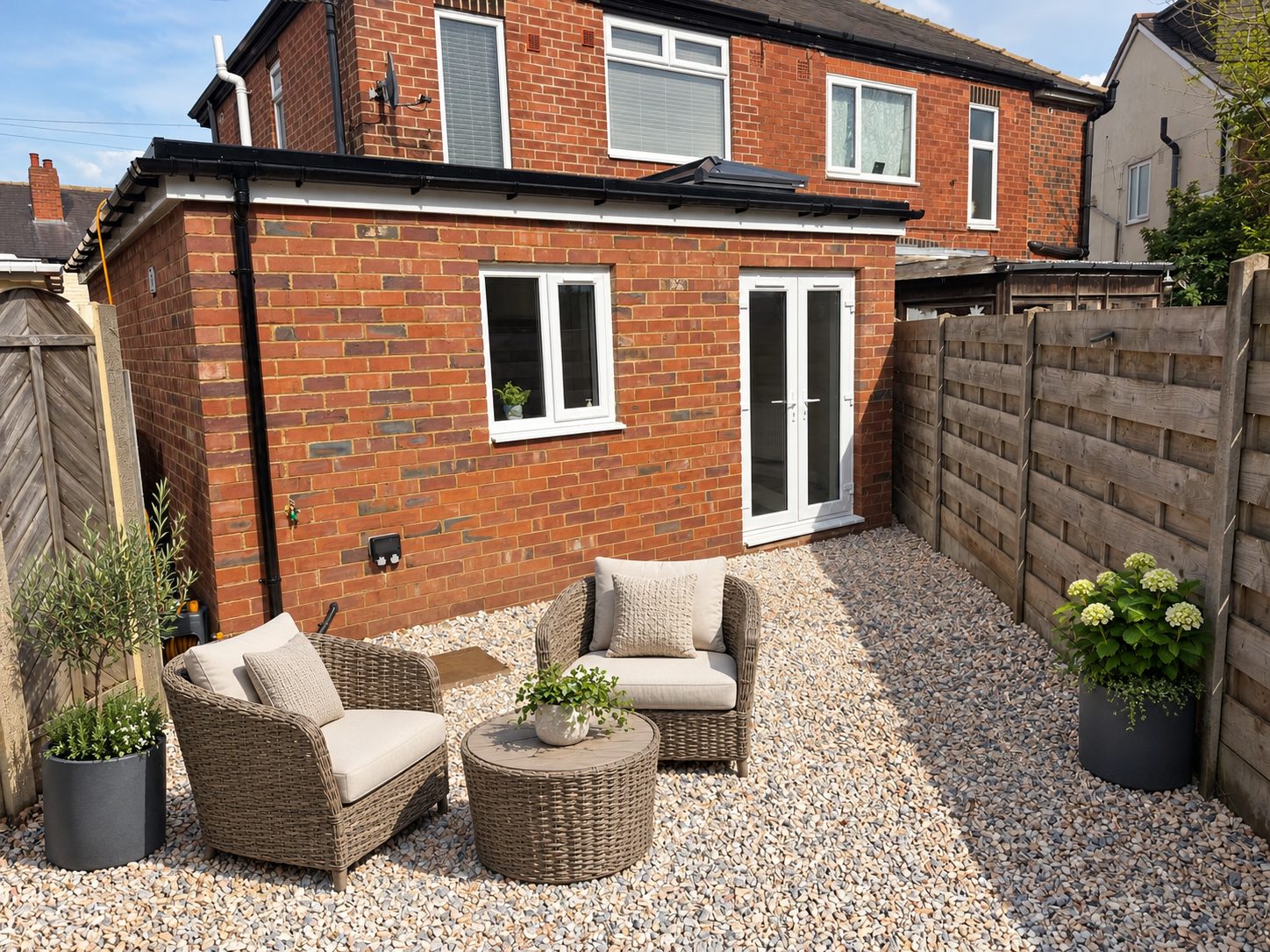 Single-storey red brick rear extension with a flat roof, white French doors and a window, on a semi-detached house in Rothwell, Leeds
