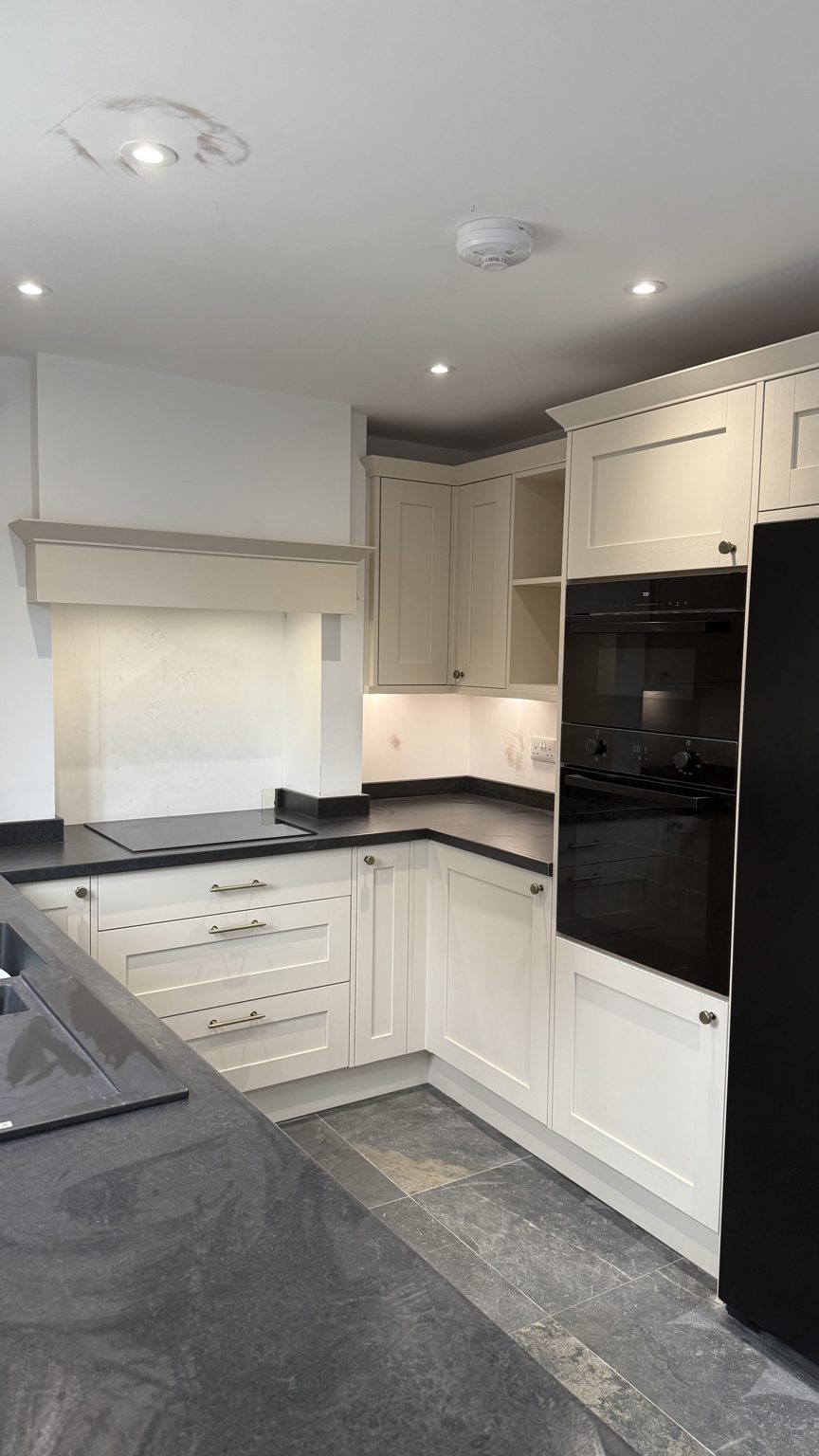 Howdens kitchen with the false chimney surround over the hob at handover, ceiling not yet decorated, in the Rothwell extension